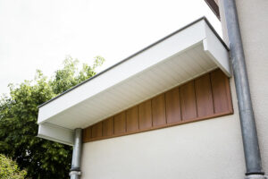 Habillage bandeaux et sous faces blanches et bardage aluminium marron sur le mur de cette maison réalisés par Bourguignon Dal'Alu