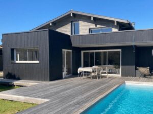 Bardage aluminium gris foncé pour cette maison avec piscine et plage en bois par Bourguignon Dal'alu